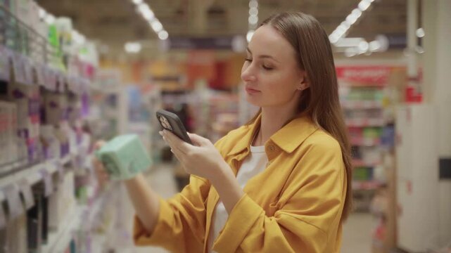 A woman scans tampons in a store aisle, carefully checking the packaging and making informed choices about her menstrual health. She is using a mobile device for assistance.