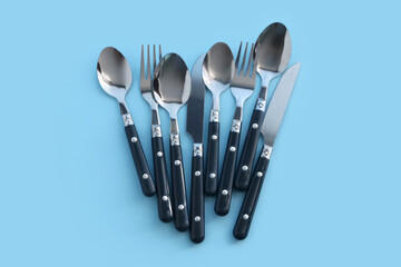 Stainless steel cutlery on blue background