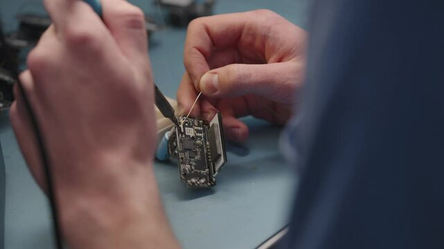 Manual soldering of a large circuit board contacts transmitters receivers relays resistors Coils with Chips Microchips macro detail