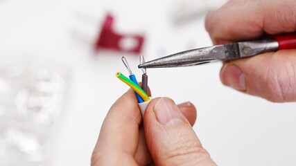 Master technician crimps sleeve on wire for appliance repair project