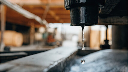 Close-up of water droplet falling from cooling tower, symbolizing Legionnaires' disease risk in industrial water systems, environmental health and safety concept.