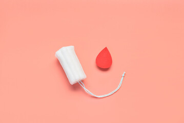 Composition with menstrual tampon and blood drop made of paper on coral background