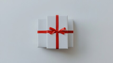 Stacked white gift boxes with red ribbon.  Neatly arranged presents on a plain white background