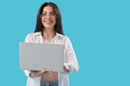 Female programmer working with laptop on blue background