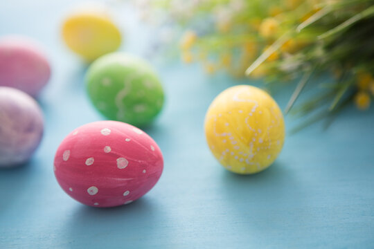 Easter eggs decoration with flowers on blue wooden table