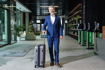Confident mature businessman with a big suitcase looking determined