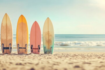 Four surfboards are lined up on the beach, with one of them being yellow. The scene is peaceful and relaxing, with the ocean in the background and the surfboards resting on the sand