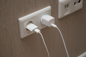 Close up of phone charger plugged in the socket