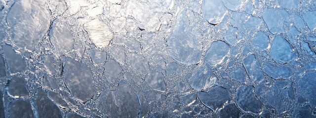 Cracked ice floes texture, cold arctic winter landscape detail showing frozen water with many cracks forming unique patterns, ice sheets