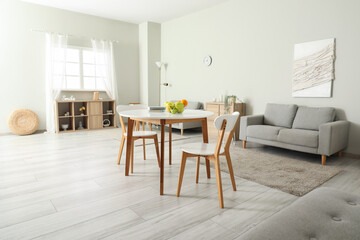 Interior of light room with dining table and sofas