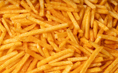 Fried chips sticks texture background, finger potato ketchup flavored chips pattern, shoestring fries