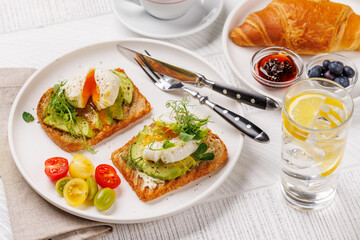 Breakfast with delicious avocado toasts and crispy croissant