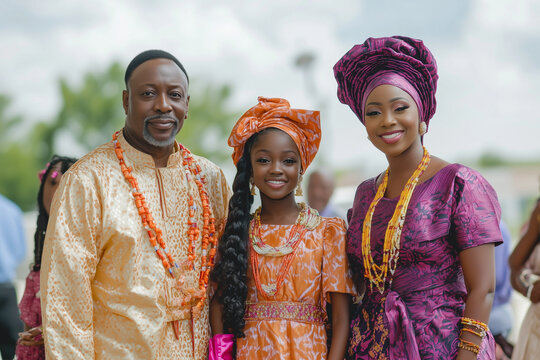 A radiant Nigerian family dressed in vibrant traditional attire, showcasing rich cultural heritage, unity, and elegance. Their intricate outfits and coral beads highlight deep-rooted African traditio