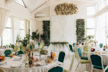Elegant Wedding Reception Decorated With Green Seats and Floral Arrangements