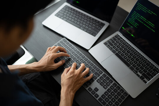Asian man software engineer Working on Computer at office desk for writing program code IT Software Engineer finding errors tech support devops creating digital