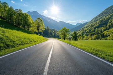 Fototapeta premium Scenic Mountain Road with Lush Green Grass and Bright Blue Sky in Daylight