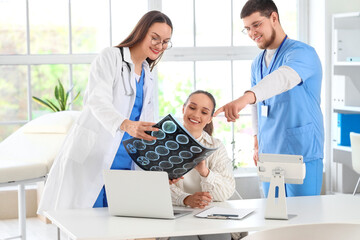Obraz premium Young doctors showing MRI scan to patient in clinic