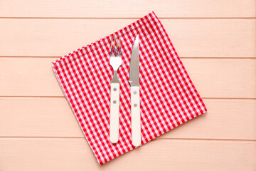 Fototapeta premium Dining etiquette and table setting, fork and knife on a red checkered napkin