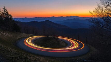 A winding road at sunset with light trails from moving vehicles.