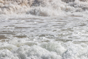 A large wave crashing onto the shore