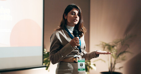 Business woman, seminar and speech for speaker in conference room for wellness training. Education, forum presentation and microphone with corporate coach on stage for public relations or development