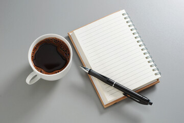 Notebook with pen and cup of coffee