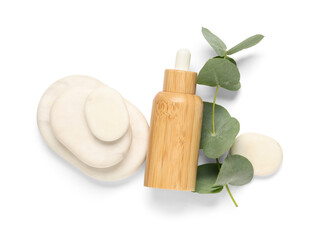 Bottle of essential oil, spa stones and eucalyptus branch on white background