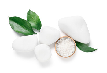 Composition with jar of sea salt, spa stones and plant leaves on white background