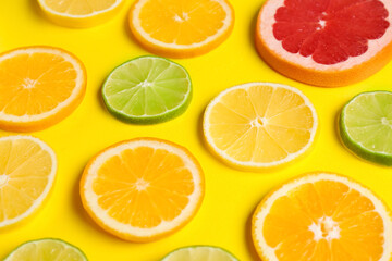 Different citrus slices on yellow background