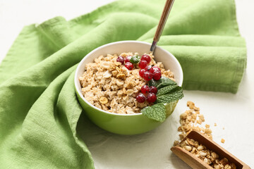 Napkin, bowl with tasty oatmeal and cranberries on white background