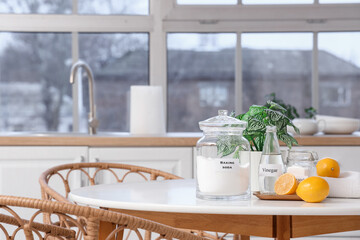 Natural cleaning supplies with lemons on dining table in kitchen