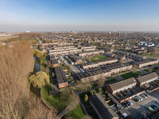 Fototapeta premium Urban landscape showcasing residential area and river in a clear sky during afternoon