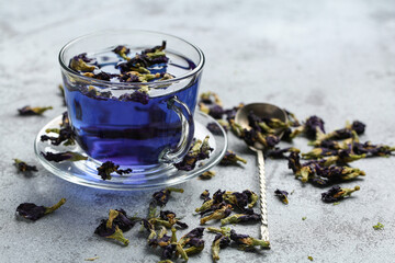 Glass cup of butterfly pea flower tea on grunge background