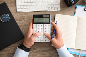 Male hands working with calculator in office. Top view