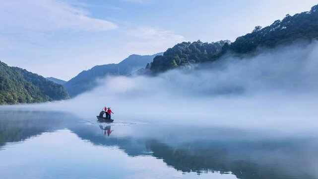 slow motion video of a fisherman casting a net on the river surface shrouded in fog, Chenzhou City, Hunan Province, China