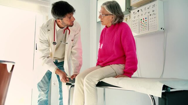 Doctor examining senior woman's knee reflexes in medical office