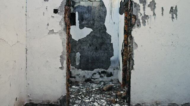 War in residential areas, broken windows and burned llage house. War in the city. City in war zone. Damage to a house as a result of artillery shelling. Armed conflict in Ukraine.