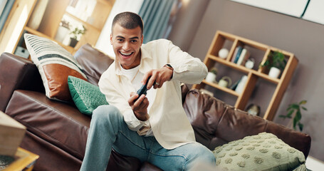 Man, video game and happy on sofa, controller and online competition with challenge, battle or esports in home. Person, relax and play with virtual contest, excited and smile on couch in living room © peopleimages.com