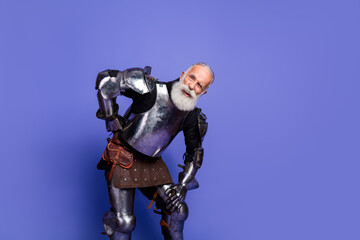 Elderly knight with a beard in full armor posing against a violet background