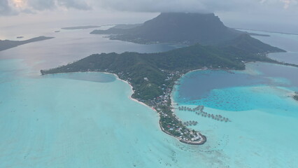 Stunning aerial view of Bora Bora island, lush vegetation, and the surrounding turquoise lagoon,...
