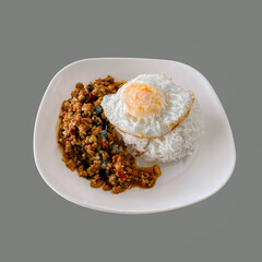 Rice with spicy fried pork with basil leaves and fried egg on white plate. Thai style food. Food concept.Spicy stir-fried  with basil, Thai food.