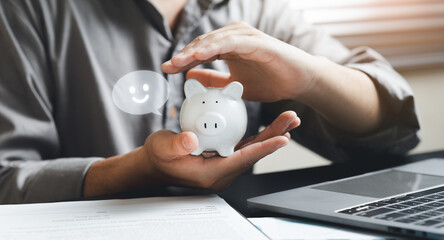 Person Holding Piggy Bank with Smiley Indicator on Digital Screen