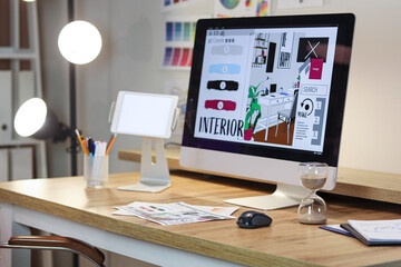 Interior designer's workplace with computer and hourglass in office at night