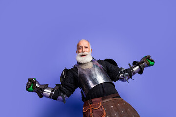 Naklejka premium Portrait of an elder man wearing medieval armor with purple background, exuding charm and confidence