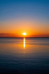 arafed view of a sunset over a calm body of water