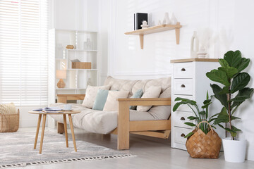 Beautiful sofa with cushions and coffee table in living room. Interior design