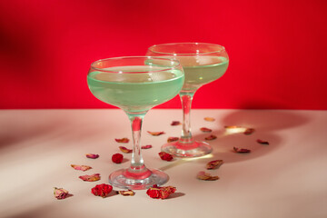 Green cocktail on red background. glass of alcoholic cocktail