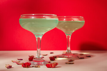 Green cocktail on red background. glass of alcoholic cocktail