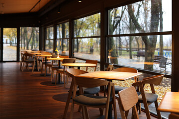 Stylish cafe with large windows and comfortable furniture. Interior design