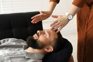 Psychologist working with patient during hypnosis session indoors, closeup